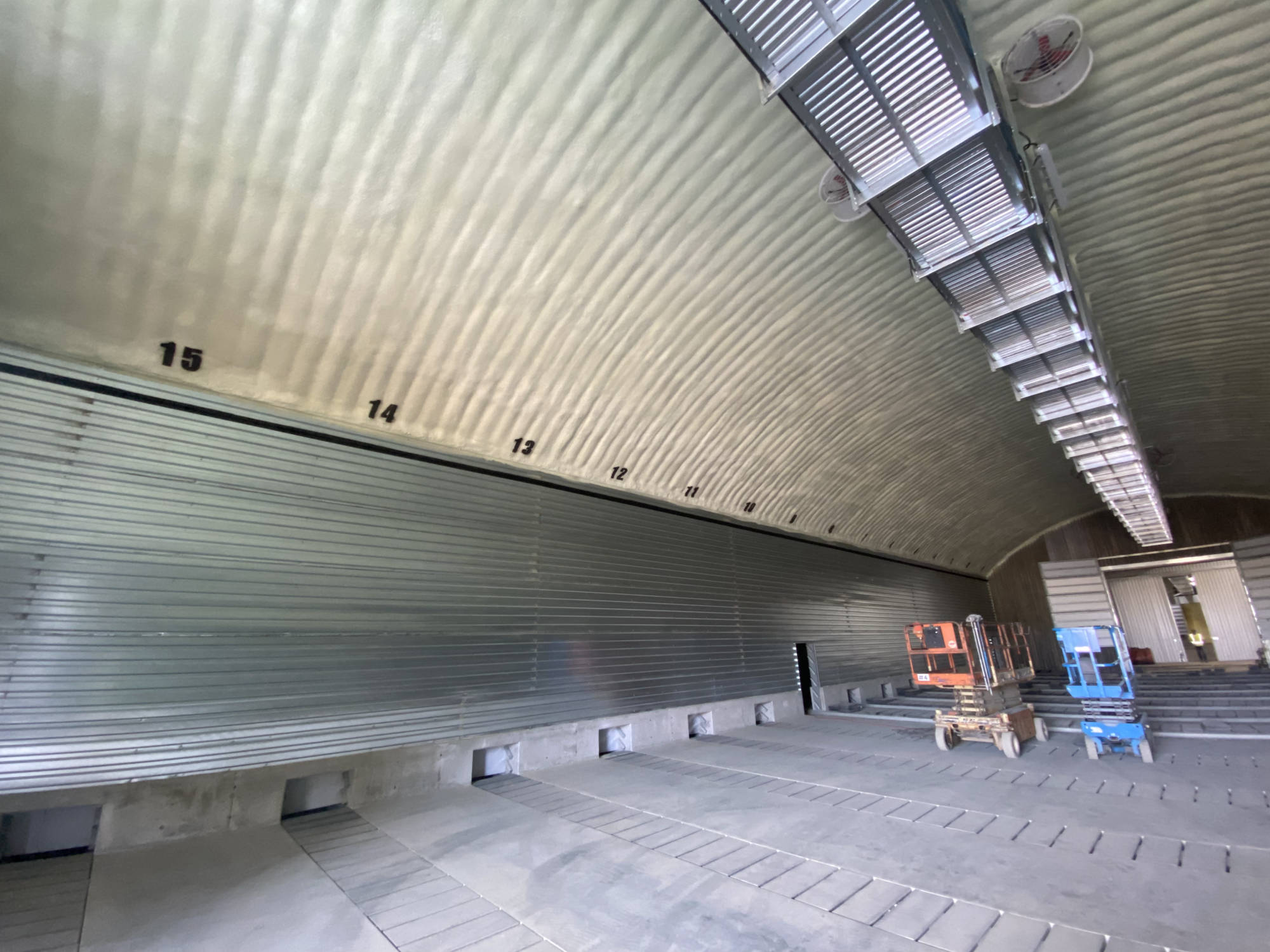 Closed-cell spray foam on the arched interior of a large storage building, with bay numbers on the foam.