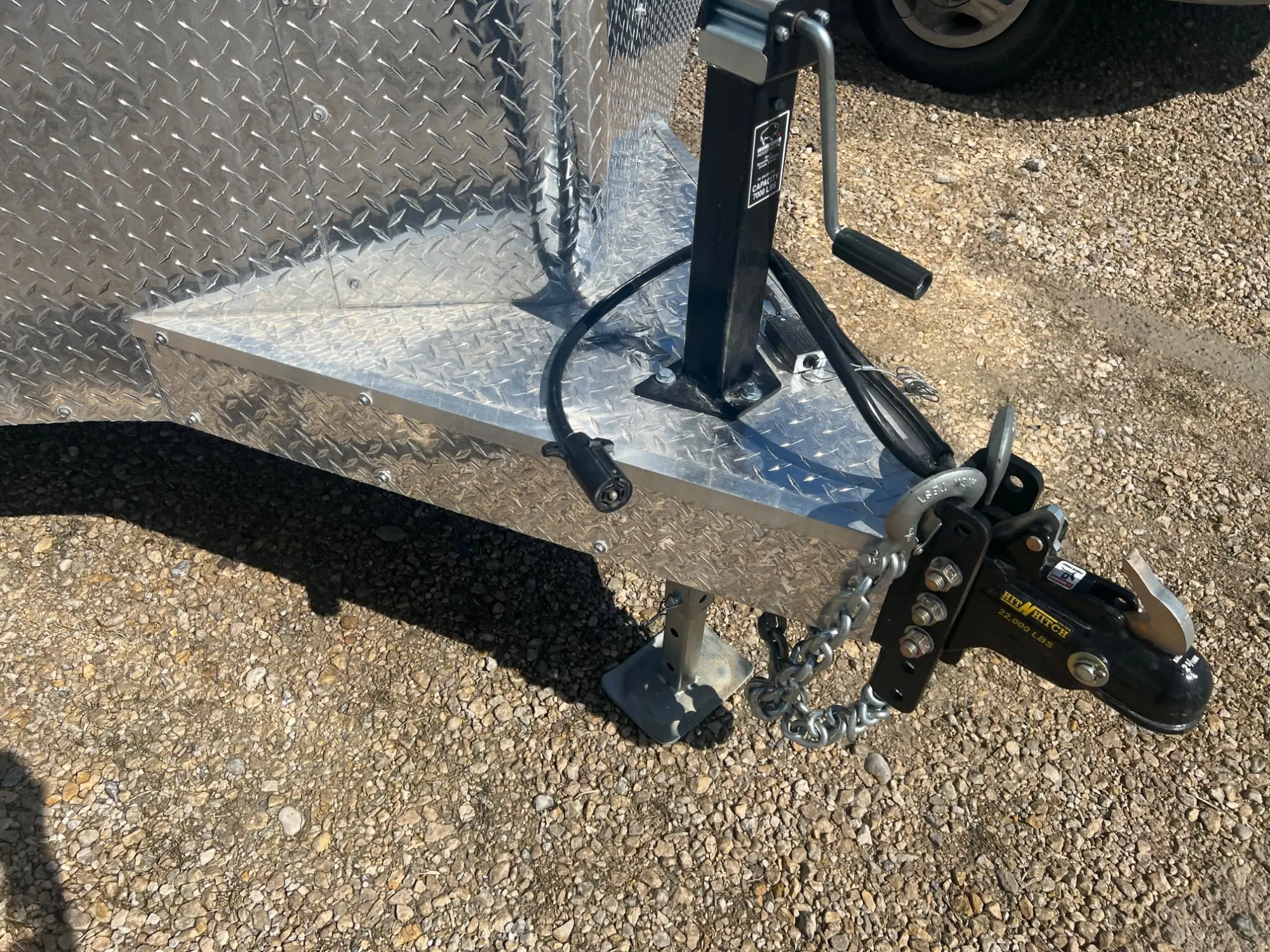 Diamond-plate trailer tongue with adjustable hitch, jack, safety chains and a 7-way plug.