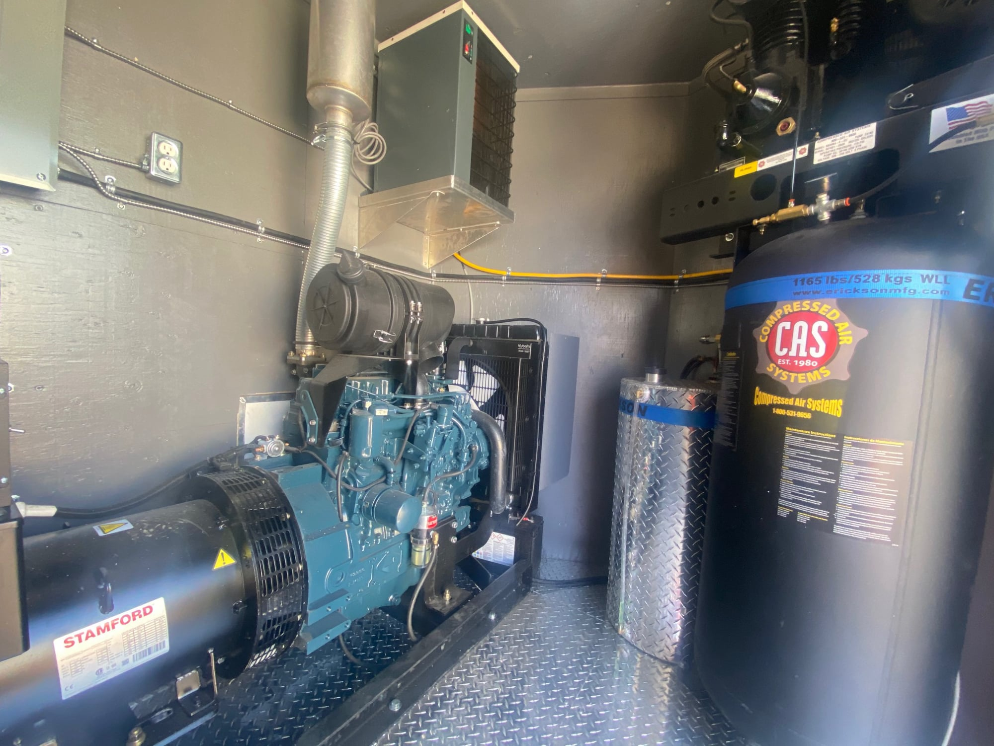 Rig generator bay with a Stamford generator, diesel engine and a tall compressed-air tank.
