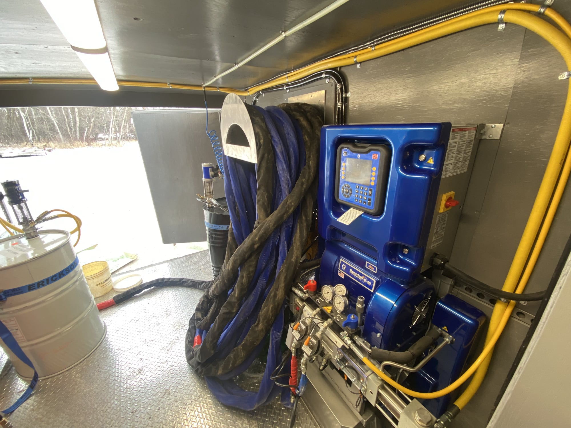 Custom spray foam rig equipment layout on a diamond-plate floor.